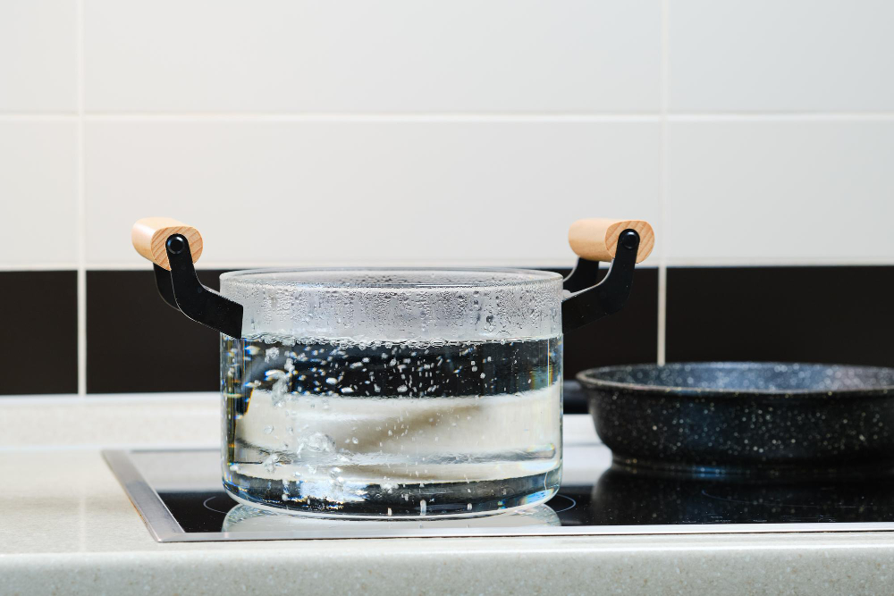 Boiling tap water on a kitchen stove as a temporary safety step during a boil water advisory when germs are a concern