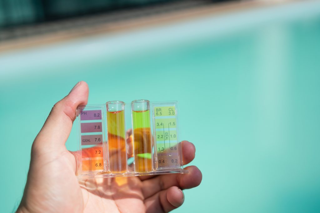 Water testing kit positioned over a water source, representing the process of measuring hardness and mineral content before adjusting water softener settings.